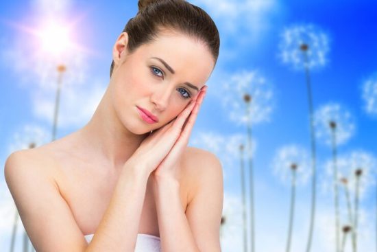 beautiful-brunette-with-hands-face-against-digitally-generated-dandelions-against-blue-sky_1134-50725